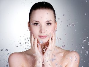 Portrait of beautiful young woman with drops of water around her face - horizontal